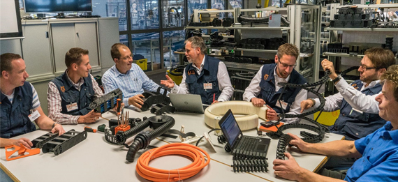 igus çalışanlar, ürünlerle birlikte masada otururken