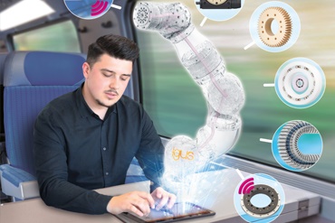 Bir kişi trende tablet üzerinden robot kolu yönlendirirken